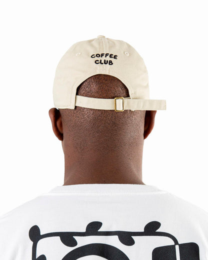 Man wearing a beige dad hat in organic cotton, 6 panel hat, low profile, embroidered logo