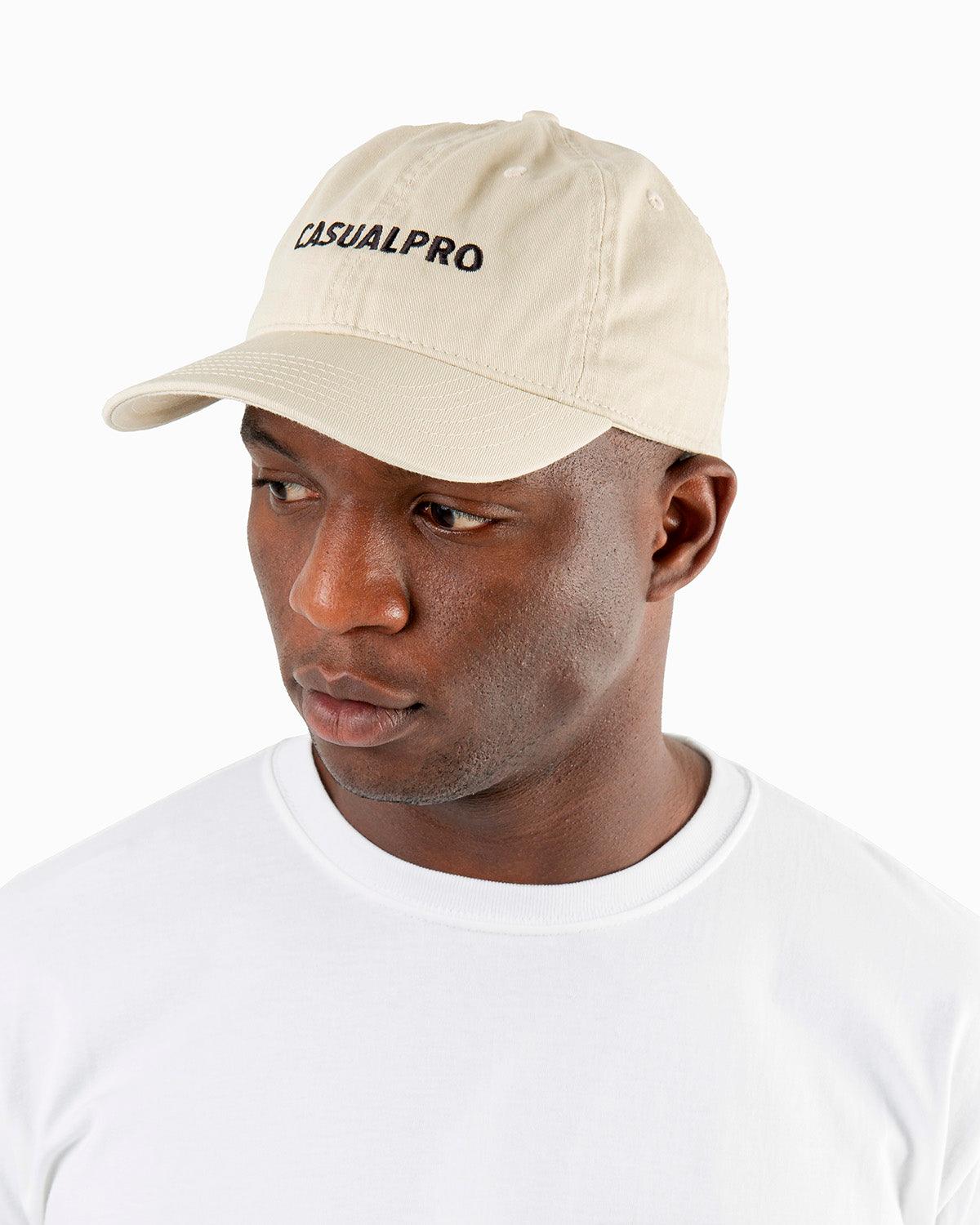 Man wearing a beige dad hat in organic cotton, 6 panel hat, low profile, embroidered logo
